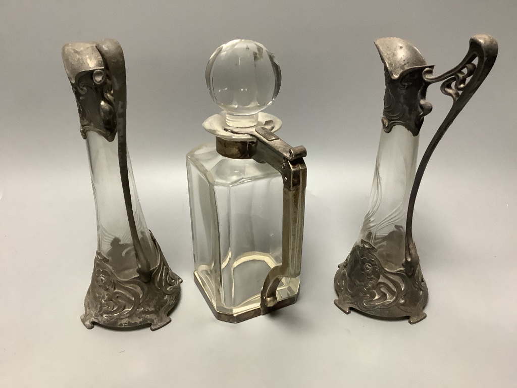 A pair of WMF style pewter-mounted glass jugs and an electroplate mounted spirit decanter, tallest 23cm